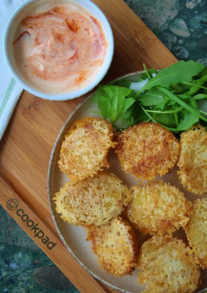 Una foto de Patatas especiadas con parmesano crujiente y salsa de yogur y sriracha 🌶