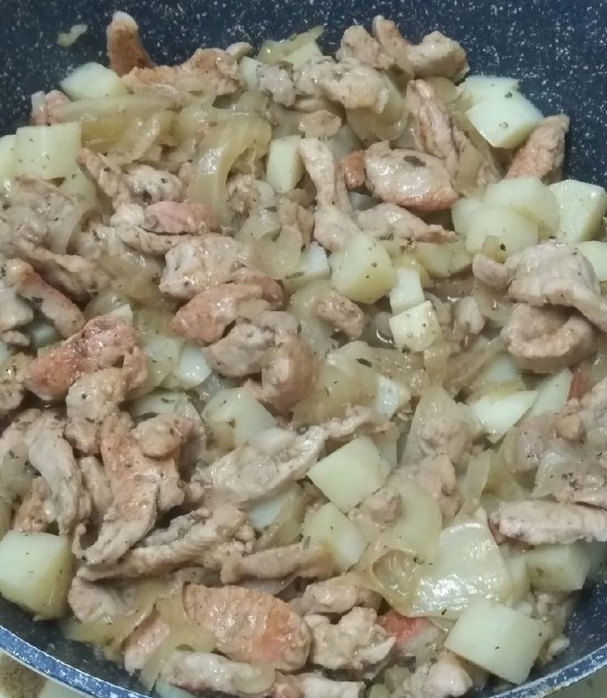 Una foto de Milanesa de cerdo con papa y cebolla