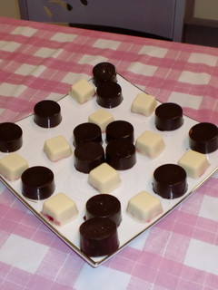Una foto de Bombones de chocolate blanco y frutos rojos y chocolate negro con frutos secos