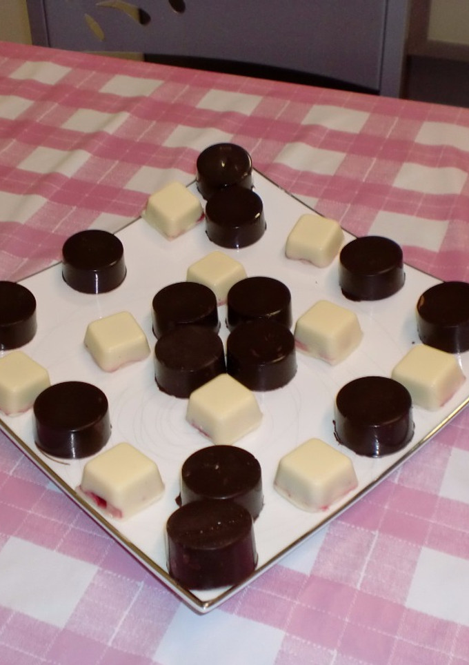 Una foto de Bombones de chocolate blanco y frutos rojos y chocolate negro con frutos secos