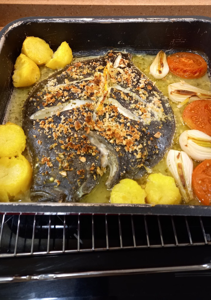 Una foto de Rodaballo al horno con patatas, verduras y almendras