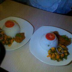 A picture of Braised rice with deep fried chicken and mixed vegetables.
