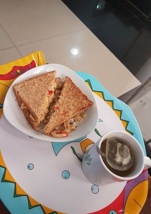 A picture of Sandwich + scrambled eggs + green tea.