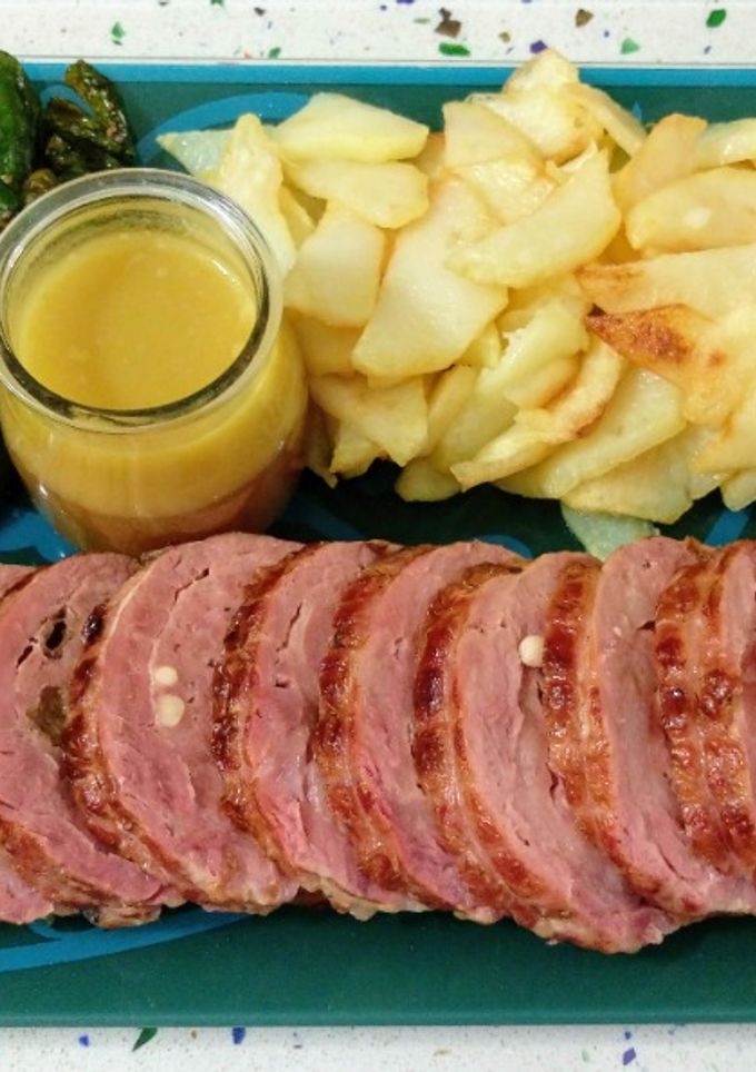 Una foto de Solomillo ibérico relleno de frutos secos y patatas con pimientos de padrón fritos