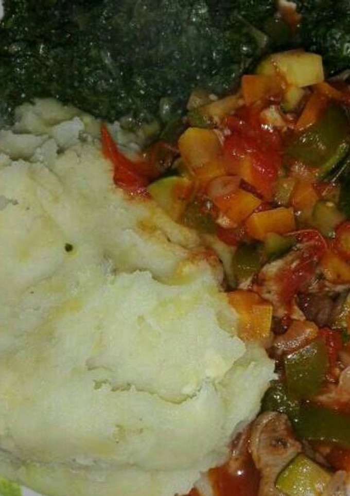 A picture of Mashed potatoes with beef stew and vegetables.