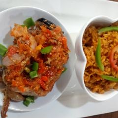 A picture of Jollof rice with cat fish pepper sauce.