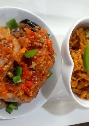A picture of Jollof rice with cat fish pepper sauce.