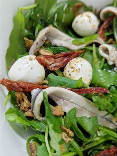 Una foto de Ensalada de boquerones con rúgula y tomates secos