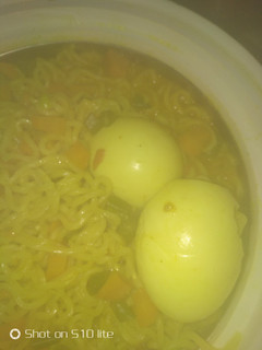 A picture of Watery veggies noodles with boiled eggs.