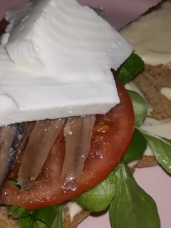 Una foto de Sándwich de canónigos, tomate, queso fresco y anchoas