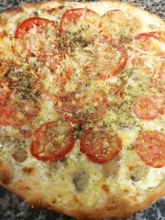 Una foto de Pizza de champiñones con tomate😋🍕