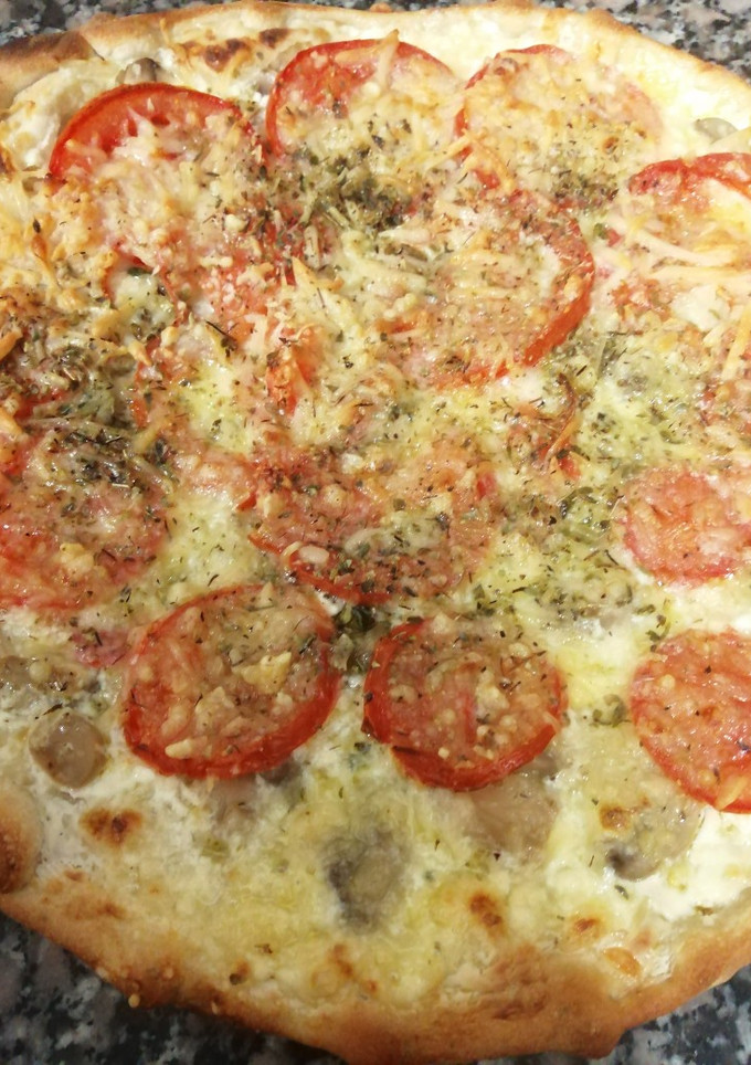 Una foto de Pizza de champiñones con tomate😋🍕