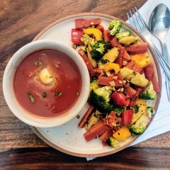 A picture of Tomato Soup with sauteed garlic vegetables.