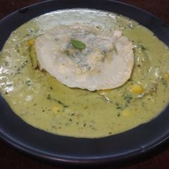 A picture of Ravioli in pesto sauce.