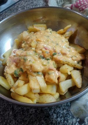 Una foto de Papas rústicas con cheddar panceta y verdeo