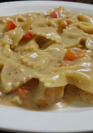 A picture of Bowties with veggies in creamy sauce.