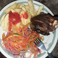 A picture of Homemade fries, chicken and kachumbari.