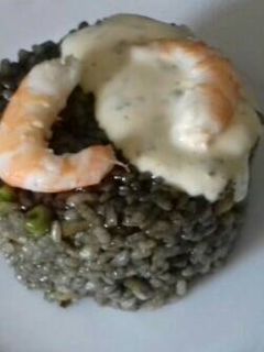 Una foto de Arroz negro con gambas, pota y salsa alioli
