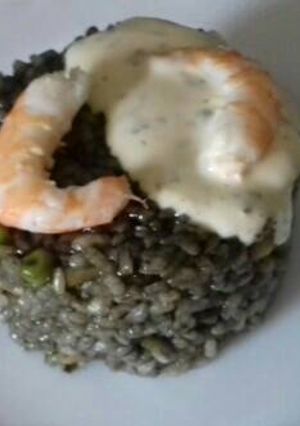 Una foto de Arroz negro con gambas, pota y salsa alioli