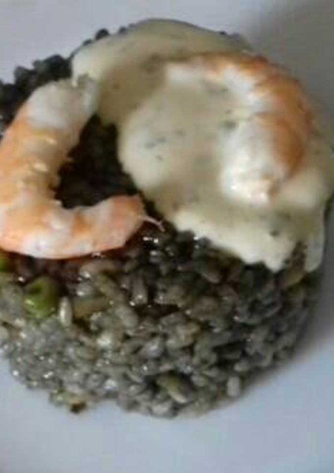 Una foto de Arroz negro con gambas, pota y salsa alioli