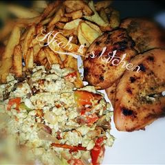A picture of Fried potatoes,scrambled egg and roasted chicken.