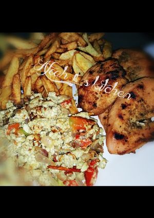 A picture of Fried potatoes,scrambled egg and roasted chicken.