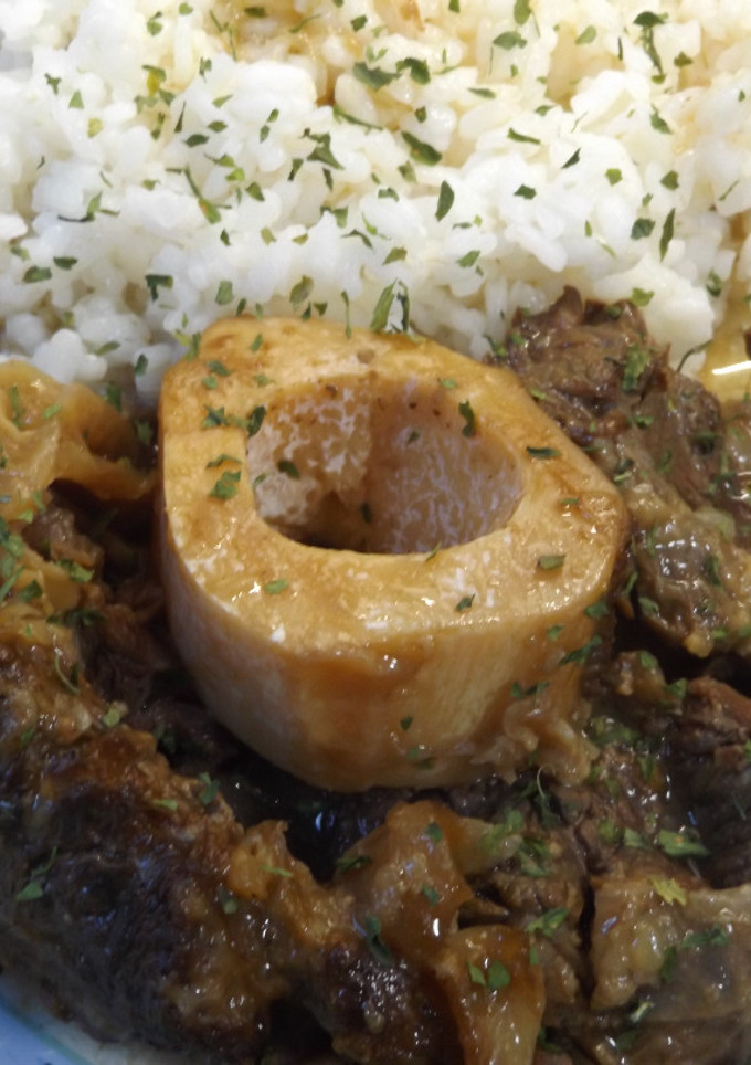 Una foto de Ossobuco con arroz a la milanesa