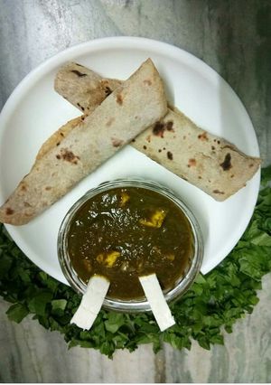 A picture of Palak paneer with roti roll.