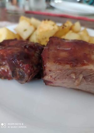 Una foto de Costillitas de cerdo a la barbacoa con papas al horno