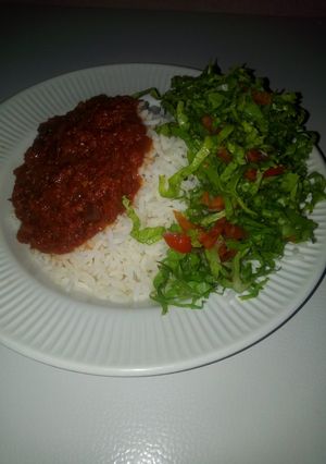 A picture of Rice and stew with salat.