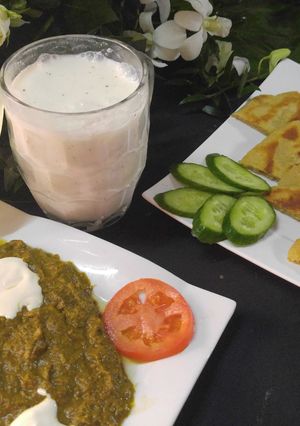 A picture of Makai ki Roti and sarso ka sag and lassi.