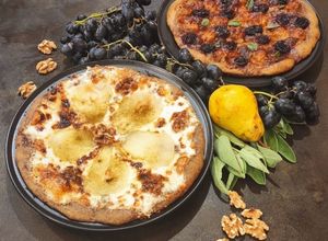 Foto di Focacce di grano arso e saraceno con: Taleggio pera noci fava tonka E... salsiccia uva e mozzarella