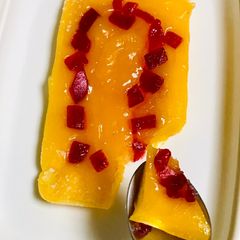 A picture of Orange pudding with dash of tutti frutti.