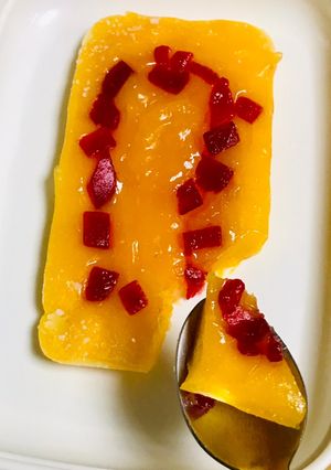 A picture of Orange pudding with dash of tutti frutti.