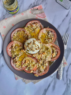 Una foto de Carpaccio de tomates con pesto y burrata