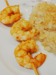 Una foto de Brochetas de langostinos marinados y arroz en salsa de soja