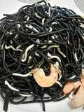 Spaghettis negros con gulas y langostinos