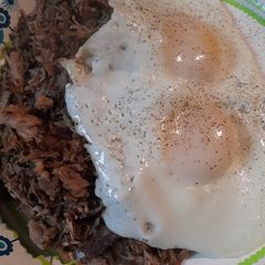 A picture of Poivre Noir Sauce with Pulled Pork and Eggs.