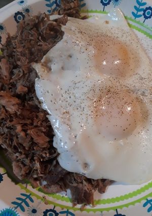 A picture of Poivre Noir Sauce with Pulled Pork and Eggs.