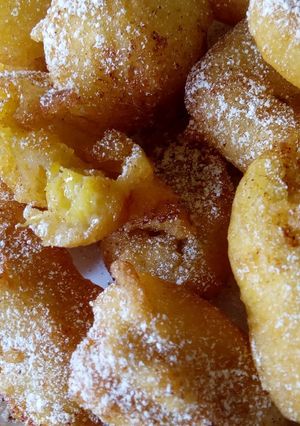 A picture of Sweet Banana fritters with dusting of icing sugar n cinnamon.