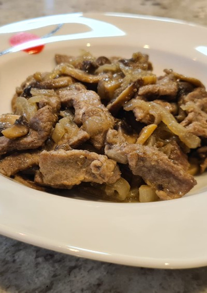 Una foto de Ternera encebollada con champiñones