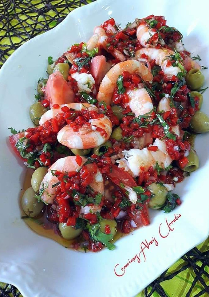 Una foto de Langostinos y tomates con chimichurri de pimientos de piquillo