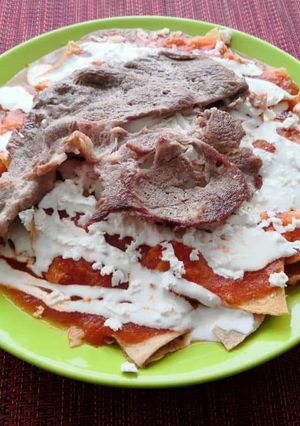 A picture of Chilaquiles Rojos with Steak.