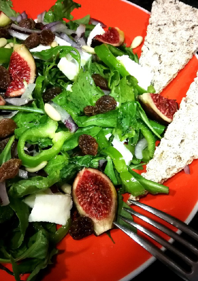 Una foto de Ensalada de rúcula con mozzarella, uvas pasas y cebolla morada