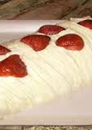 Una foto de Pionono de frutilla , crema y caramelo