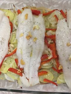 Una foto de Panga al horno con patatas panaderas, pimiento rojo y cebolla