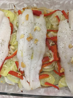 Una foto de Panga al horno con patatas panaderas, pimiento rojo y cebolla