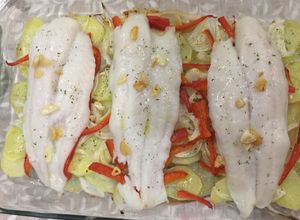 Una foto de Panga al horno con patatas panaderas, pimiento rojo y cebolla