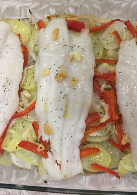 Una foto de Panga al horno con patatas panaderas, pimiento rojo y cebolla