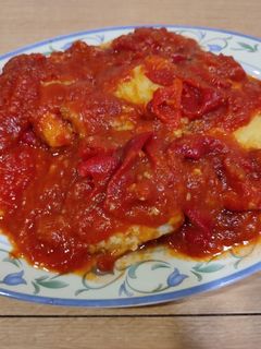 Una foto de Bacalao rebozado con tomate y pimientos asados